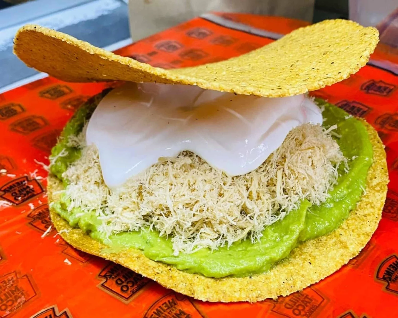 Tostada con pollo deshebrado, aguacate y crema
